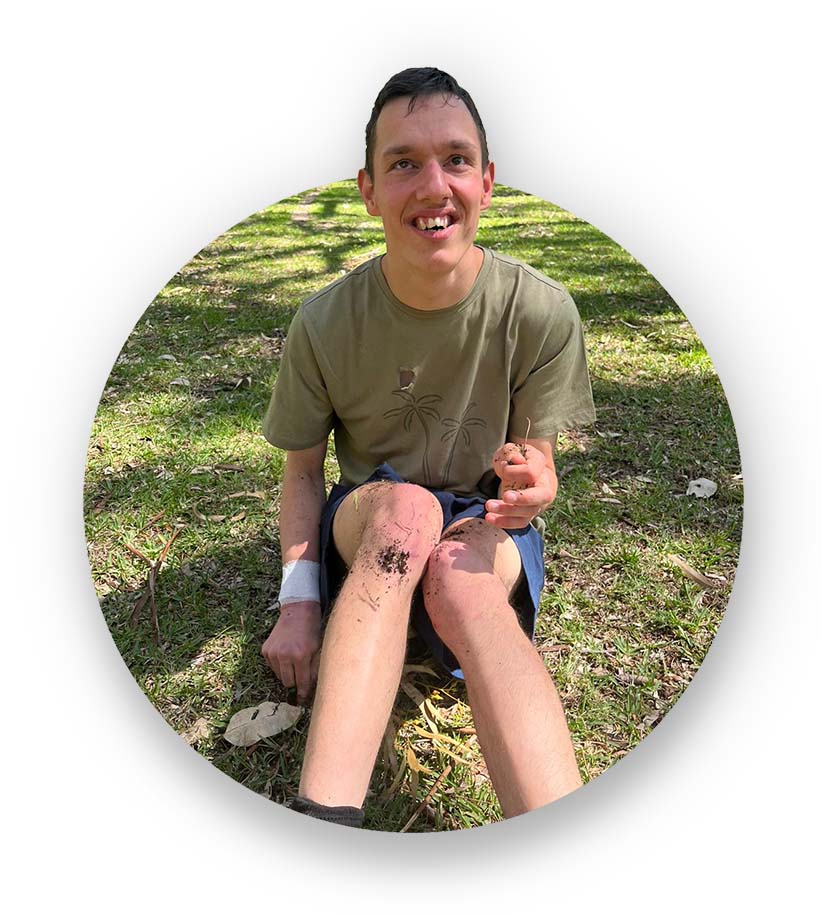 man with an intellectual disability sitting in park smiling